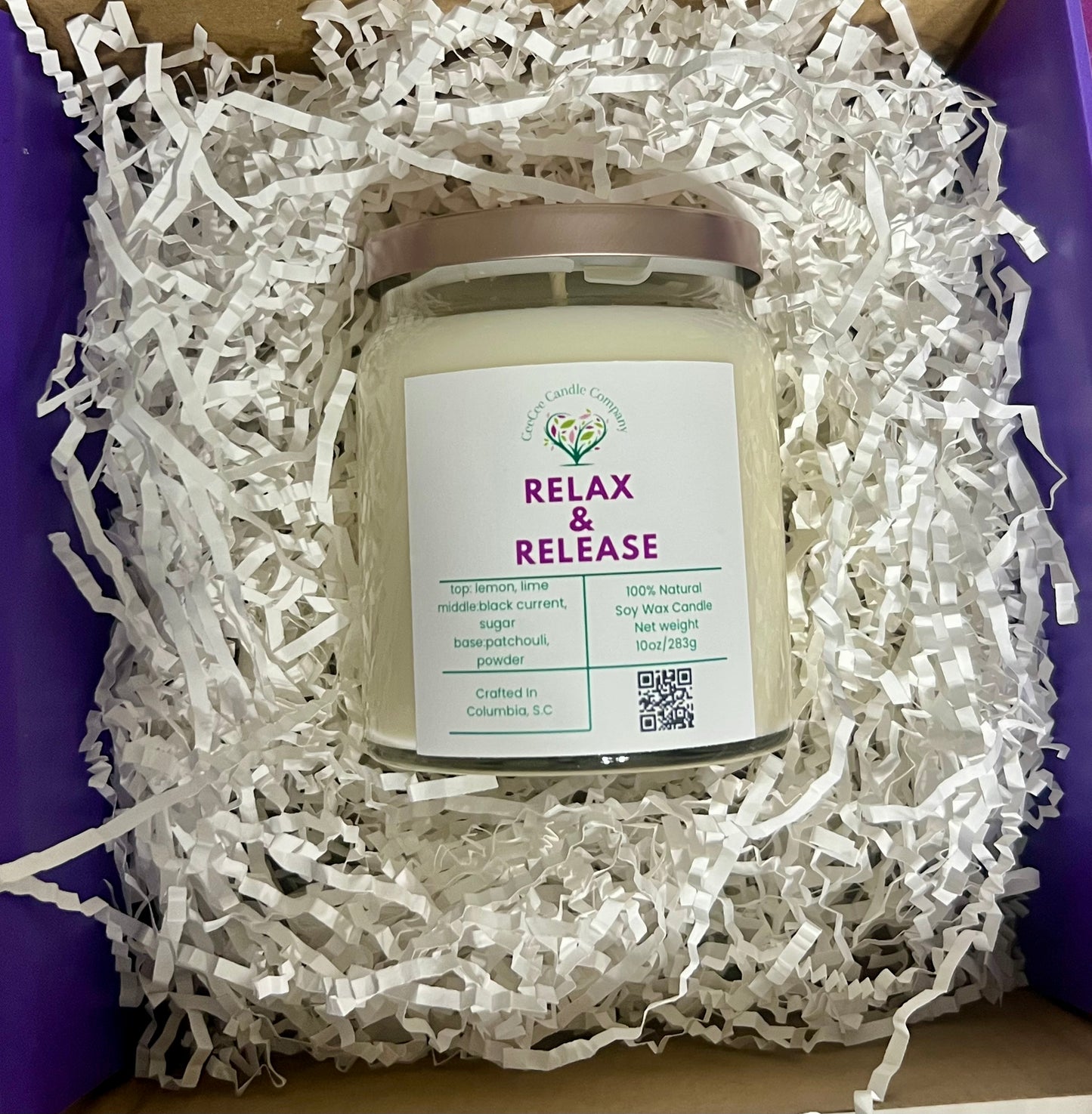 The CeeCee Candle Company Signature Apothecary Collection soy candle, handcrafted in Columbia, SC with premium fragrance oils, comes in a glass jar with silver lid and is packed in a box with white shredded paper.