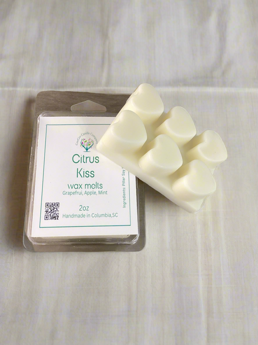 A 2oz pack of heart-shaped wax tarts from CeeCee Candle Company, labeled “Citrus Kiss wax melts: Grapefruit, Apple, Mint,” is handmade in Columbia, SC to lift your mood with fresh scents.