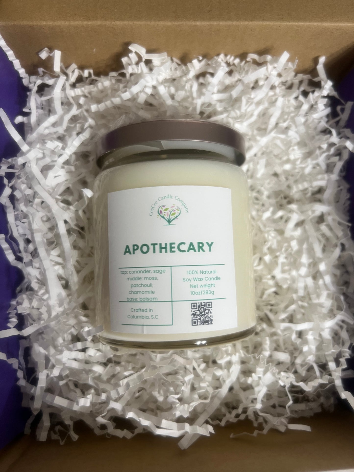 The CeeCee Candle Company Signature Apothecary Collection candle comes gift-ready in a box with white paper shreds. Made from natural soy wax and premium fragrance oils, it features a silver lid plus a scent, ingredient, and QR code label.