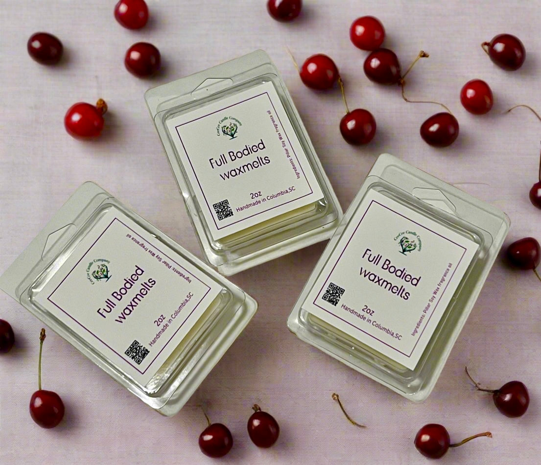 Three packages of CeeCee Candle Company's Build Your Own Wax Melts Bundle are displayed on a light surface with scattered cherries. Each 2 oz pack has a green logo, QR code, and lets you create your own customizable scent combination.
