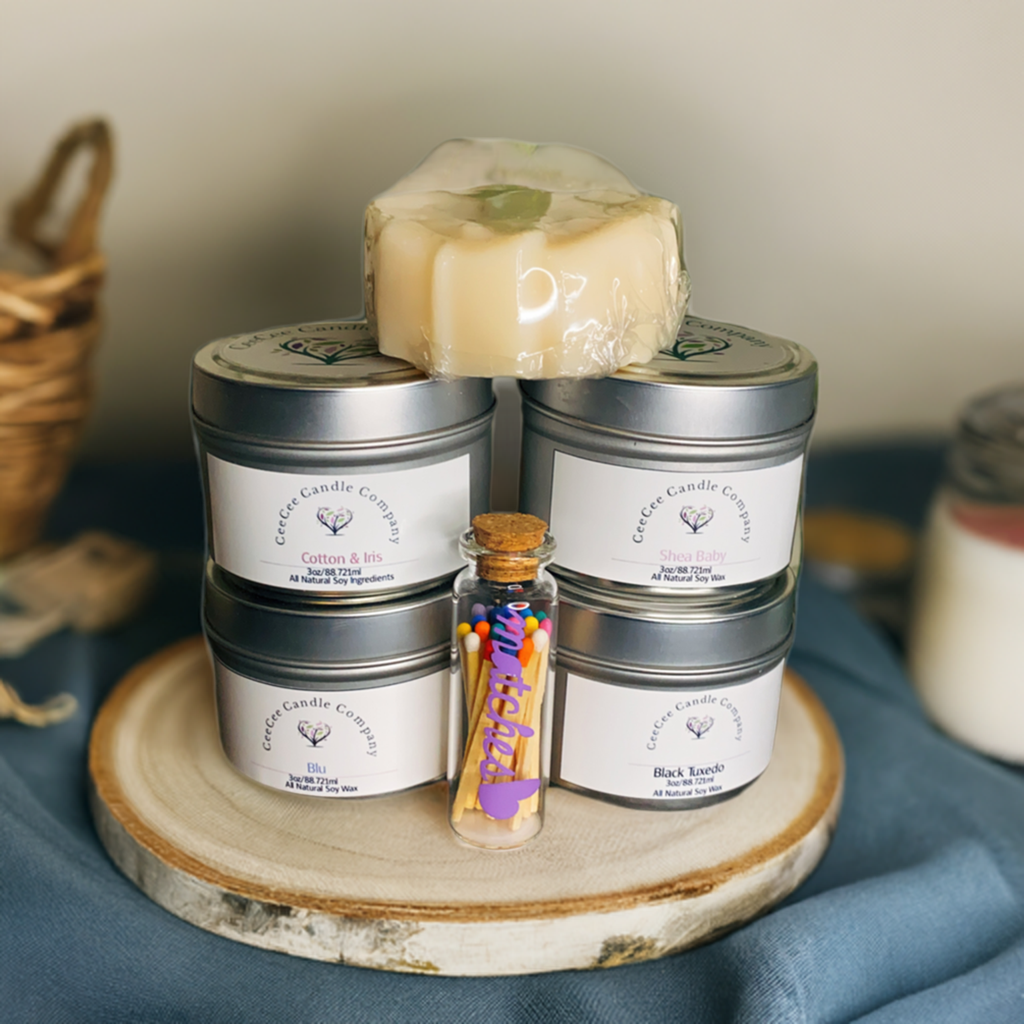 The CeeCee Candle Company Gift Box by CeeCee Candle Company features four soy candles in tins with different scents, a wrapped soap bar, and a glass vial of colorful sticks—an ideal eco-friendly self-care gift.