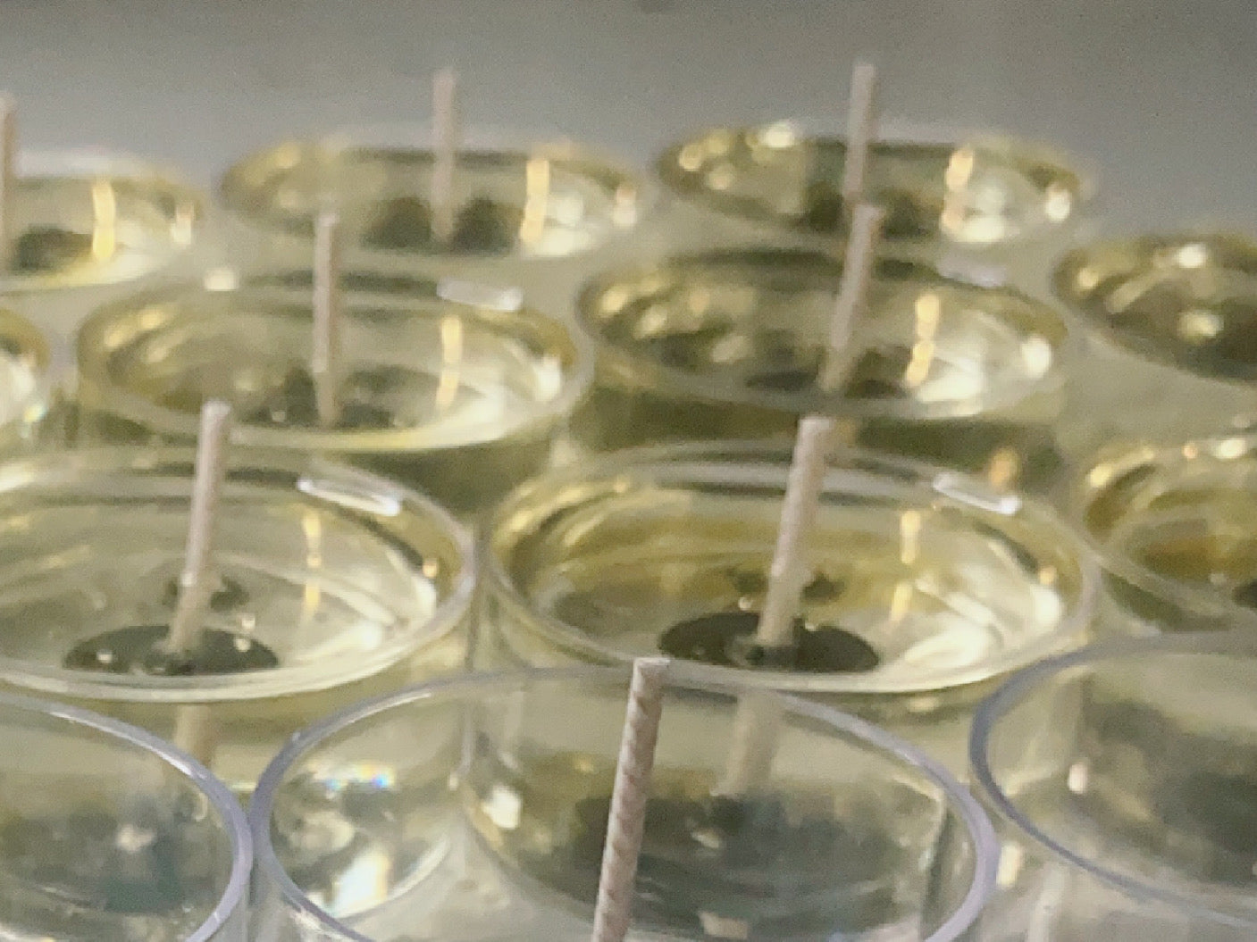 A close-up of CeeCee Candle Company’s Soy Wax Tea Light Candles shows clear glass containers filled with liquid soy wax and centered wicks, arranged in rows—perfect for eco-friendly, aromatherapy tealight candle making.