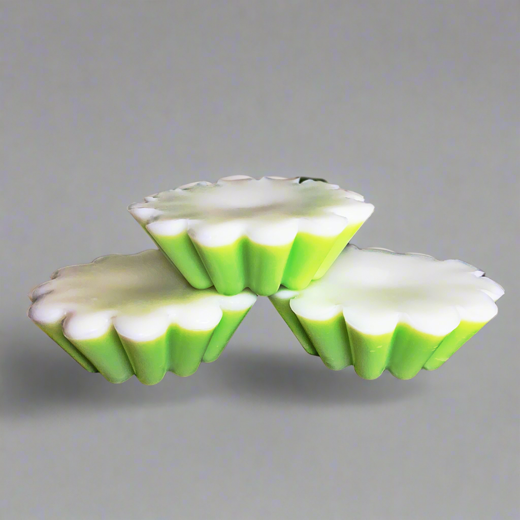 Three tart-shaped Candle Tart Melts from CeeCee Candle Company, crafted from soy pillar blend wax in green and white with scalloped edges, are stacked pyramid-style against a plain gray background.