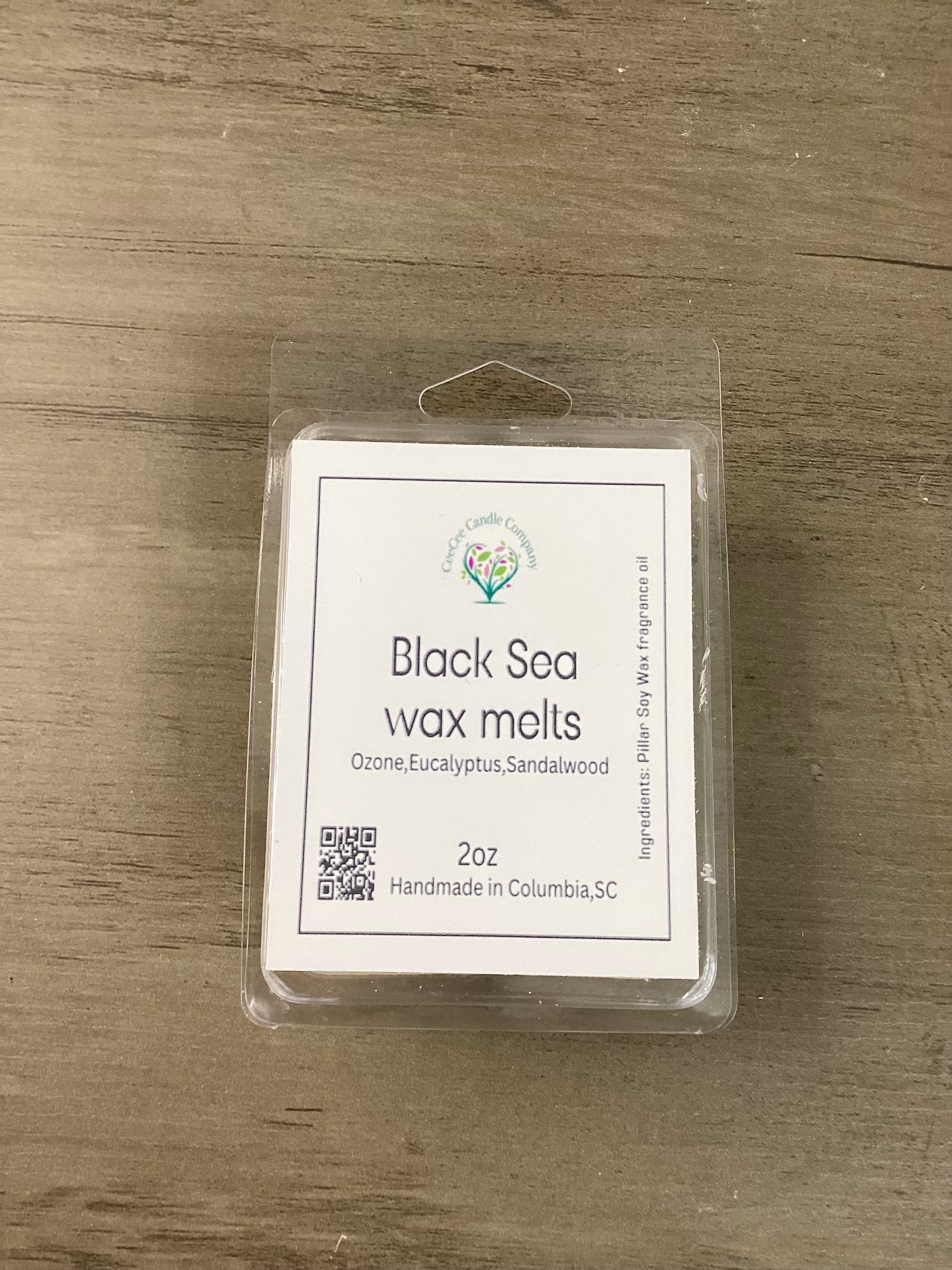 A Build Your Own Wax Melts Bundle from CeeCee Candle Company sits on a wooden surface. The label highlights scents like ozone, eucalyptus, and sandalwood and notes these handmade melts are crafted in Columbia, SC.