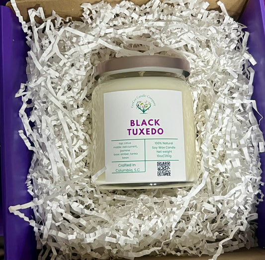 A CeeCee Candle Company Signature Apothecary Collection soy candle rests in white paper shreds inside a purple box. Made in Columbia, S.C. with premium fragrance oils by CeeCee Candle Company.