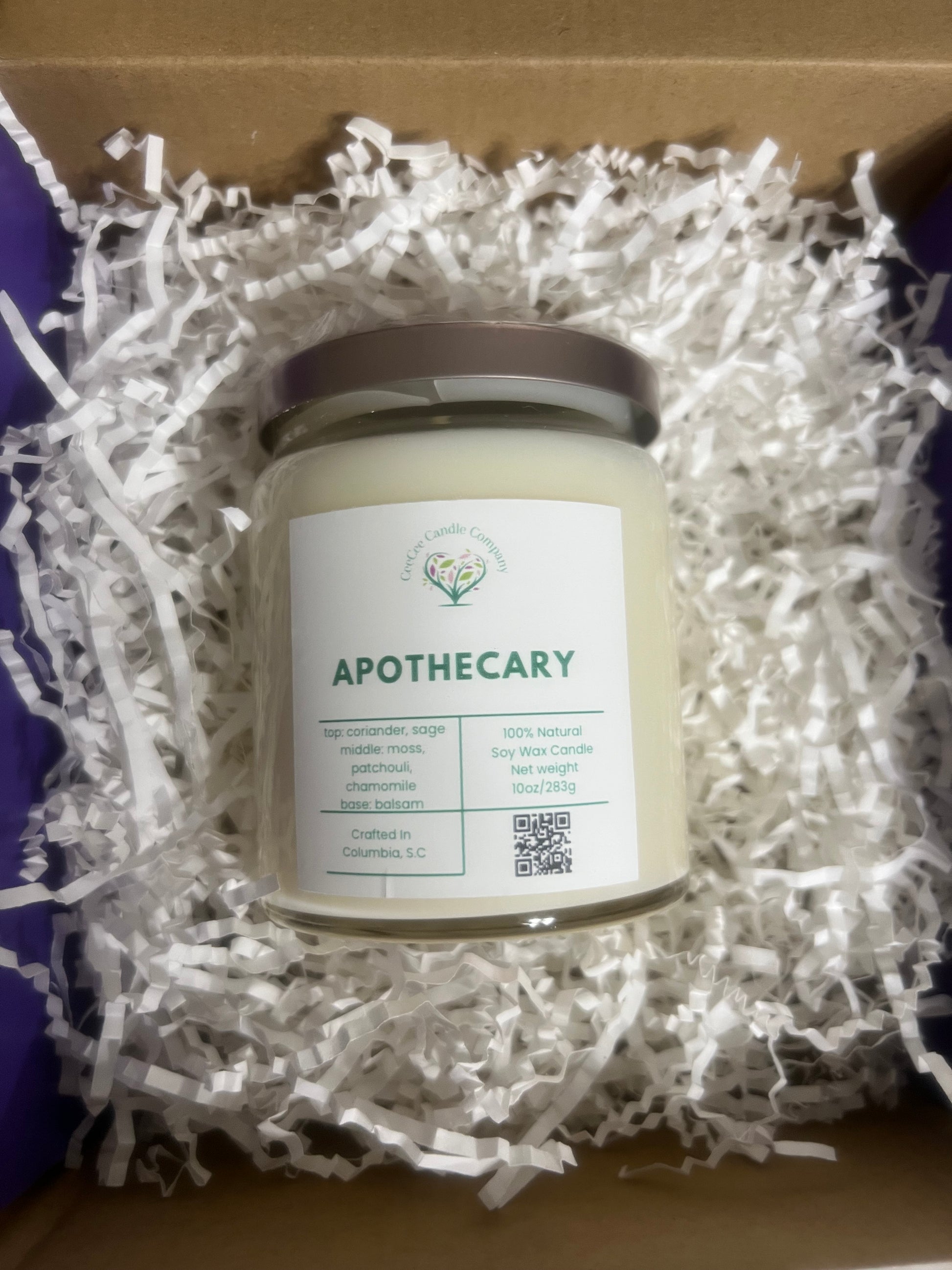 The CeeCee Candle Company Signature Apothecary Collection candle comes gift-ready in a box with white paper shreds. Made from natural soy wax and premium fragrance oils, it features a silver lid plus a scent, ingredient, and QR code label.