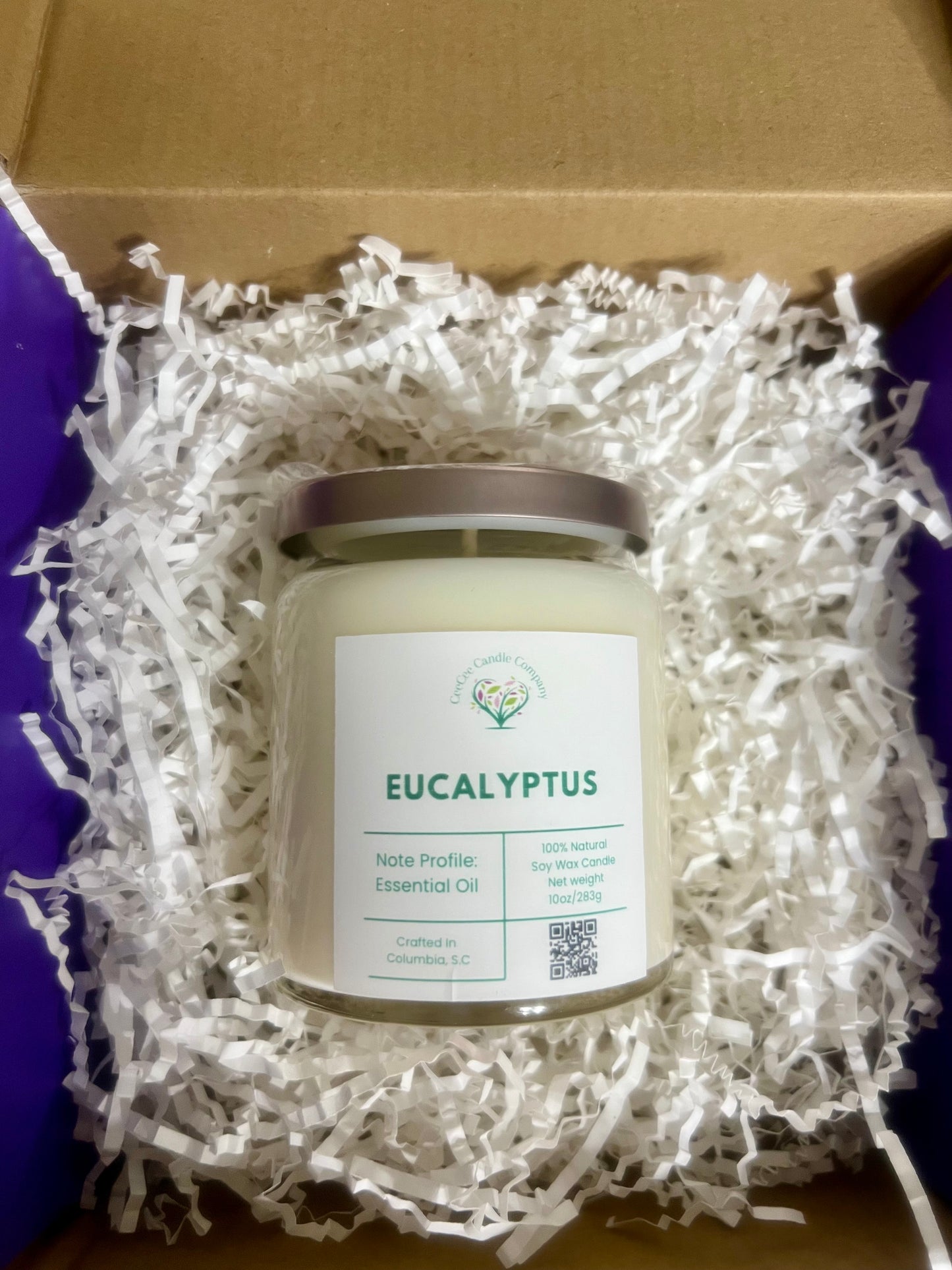 A CeeCee Candle Company Signature Apothecary Collection "Eucalyptus" soy candle sits in a box with white shreds. Made in Columbia, SC, it features 100% natural soy wax and premium fragrance oils.