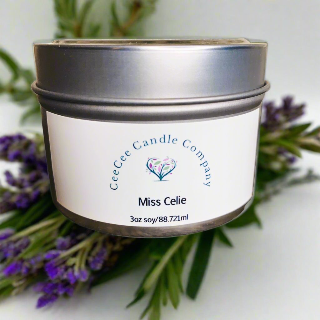 A CeeCee Candle Company Travel Size Soy Candle in a silver tin (3oz/88.7ml), made from all-natural soy wax for a mood-boosting scent, with lavender and green leaves softly blurred in the background.