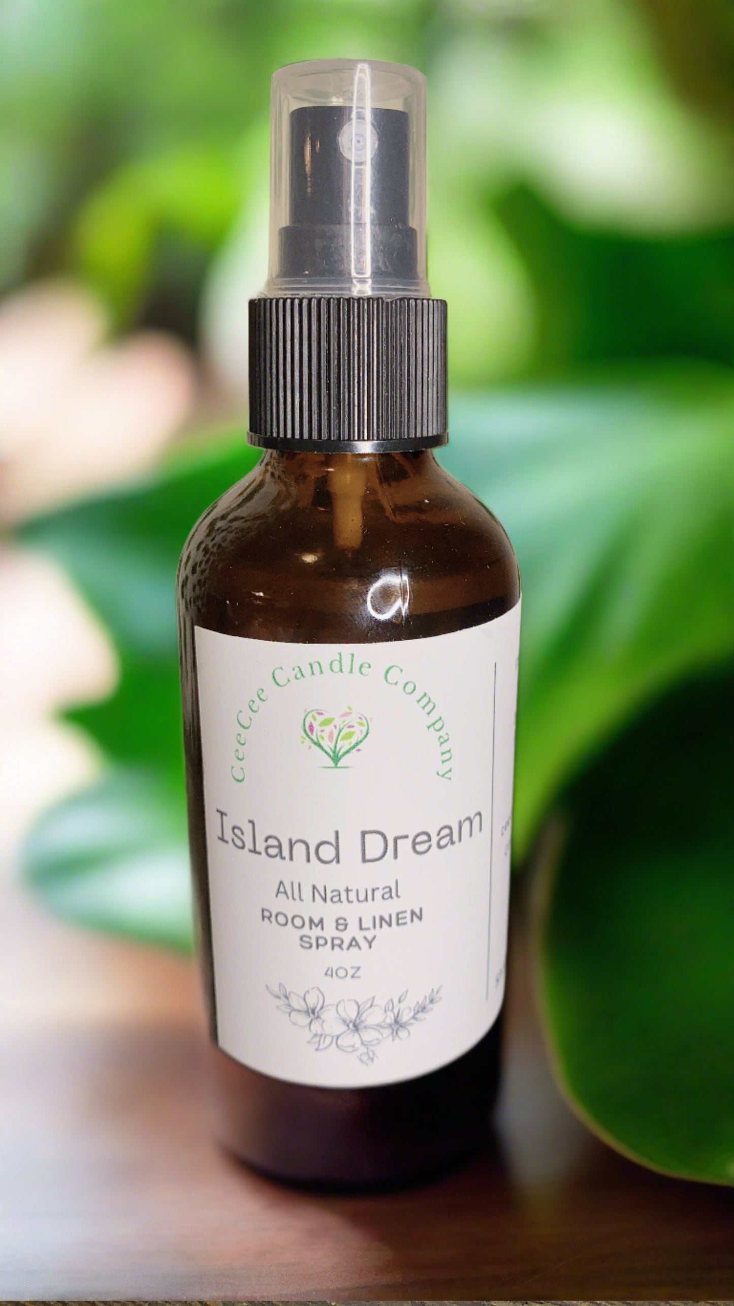 A brown spray bottle of CeeCee Candle Company Room & Linen Spray – Clean, Long-Lasting Scents is shown against a green leafy background, highlighting one of the brand’s signature fragrances.