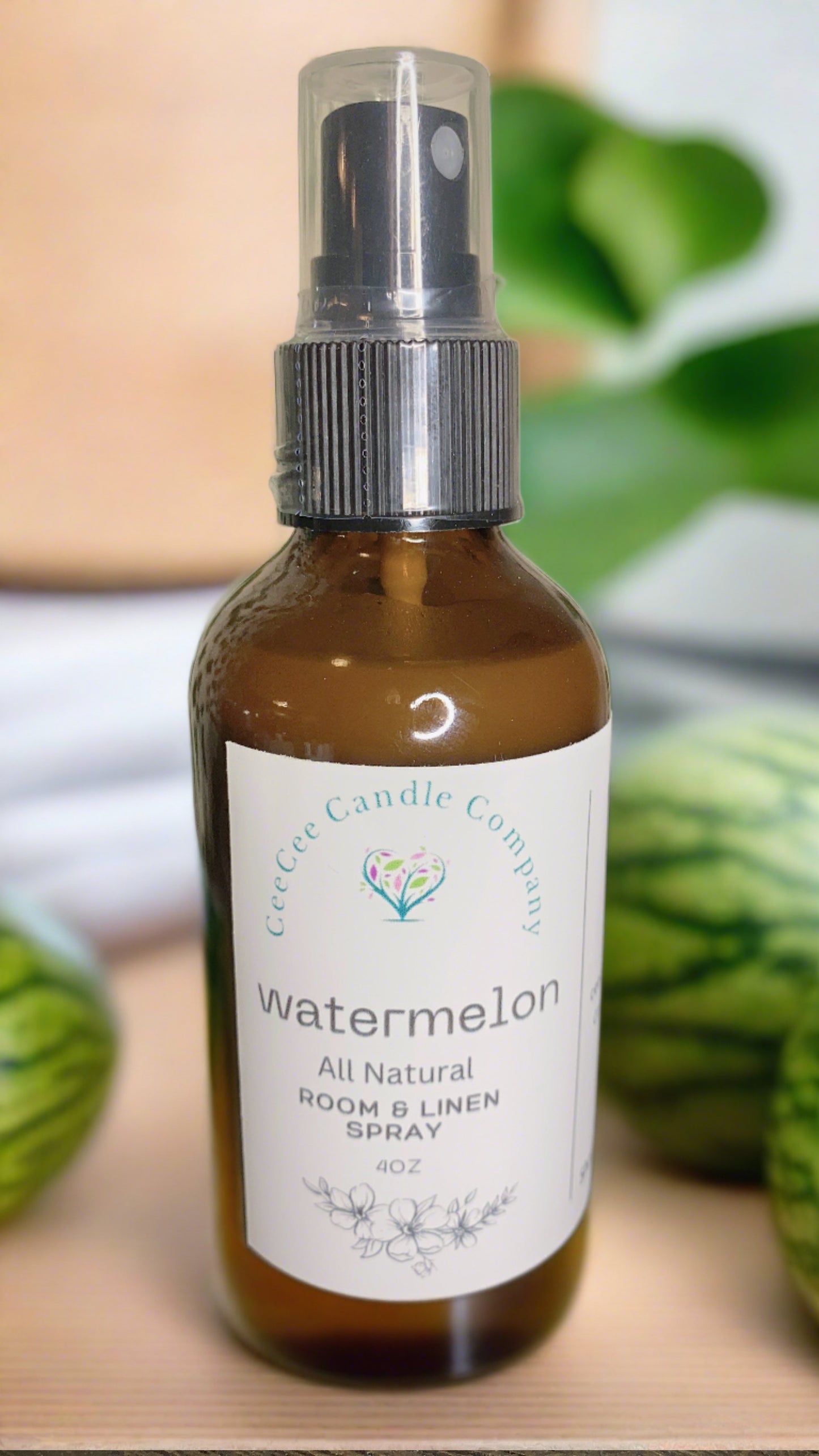 A brown glass spray bottle labeled "CeeCee Candle Company Room & Linen Spray – Clean, Long-Lasting Scents" is shown, with green watermelon patterns and blurred leaves in the background—a fresh pick from CeeCee Candle Company.